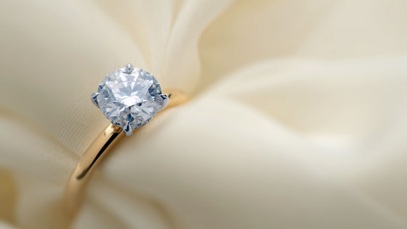 A diamond set in yellow gold with platinum prongs.