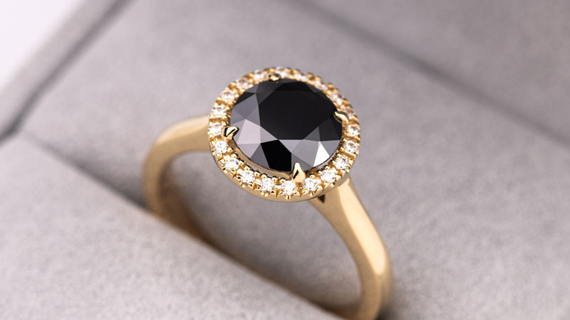 An engagement ring with a black fancy colored diamond center stone.