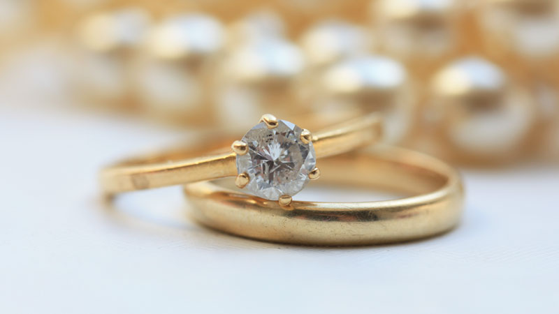 A gray fancy colored diamond set in a yellow gold ring.