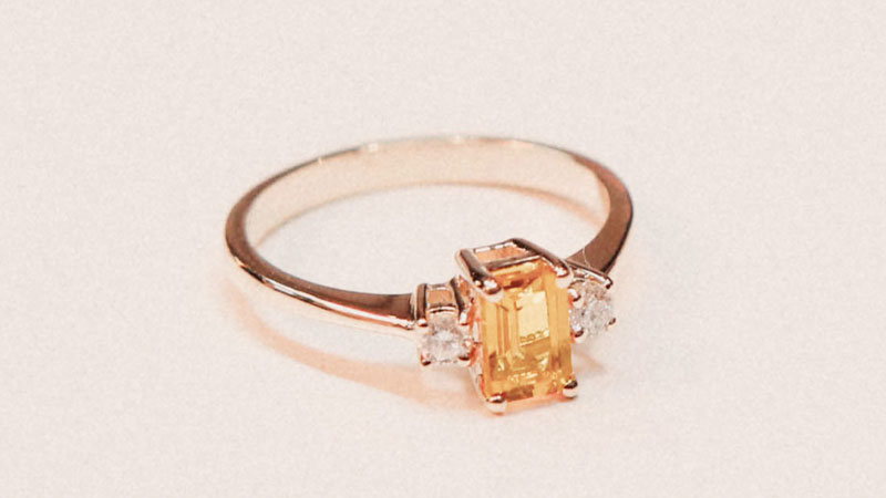 An orange fancy colored diamond engagement ring.