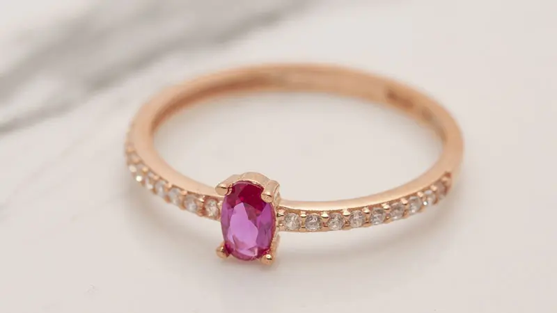 An oval cut fancy pink diamond engagement ring.