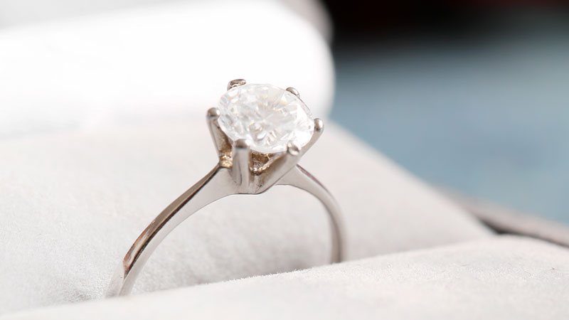 A white fancy colored diamond set in a vintage engagement ring.