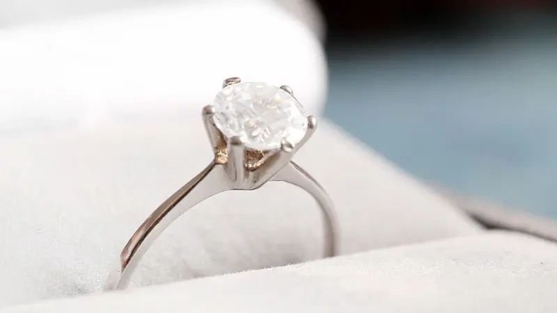 A white fancy colored diamond set in a vintage engagement ring.