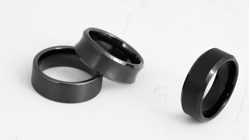 Three wedding bands made by specialized jewelry manufacturers from a base metal alloy of black tungsten and titanium.