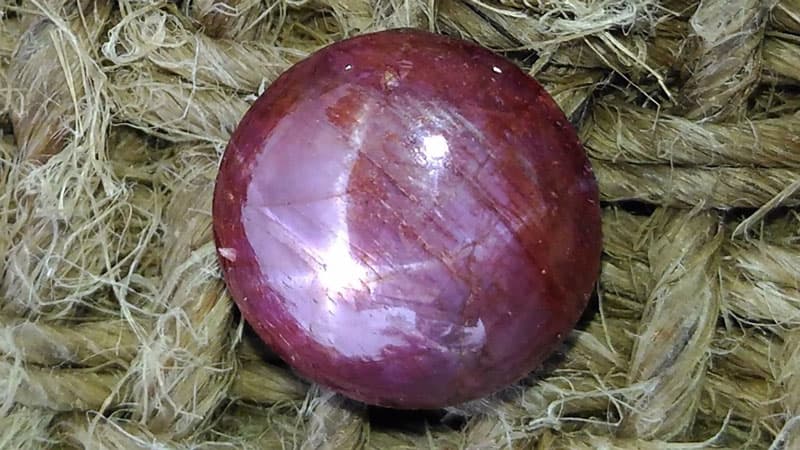 A star ruby stone with a six-rayed star dancing on its surface.