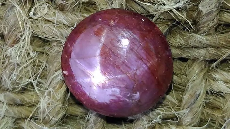 A star ruby stone with a six-rayed star dancing on its surface.