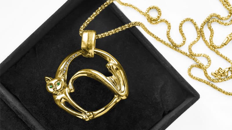 A gold cat pendant on a chain