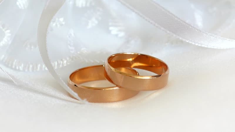 Rose gold wedding bands on white gauze