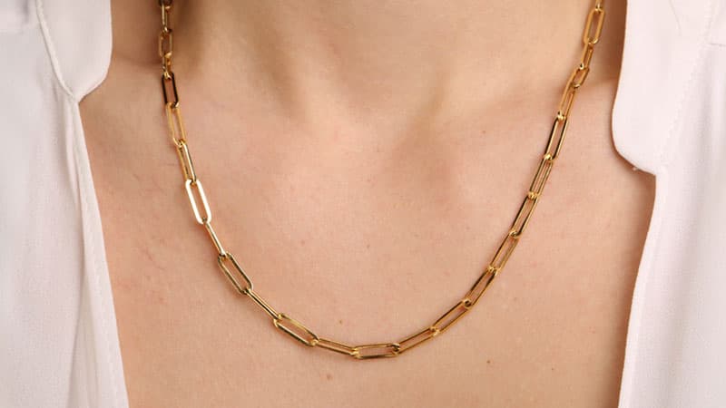 Woman wearing yellow gold necklace chain