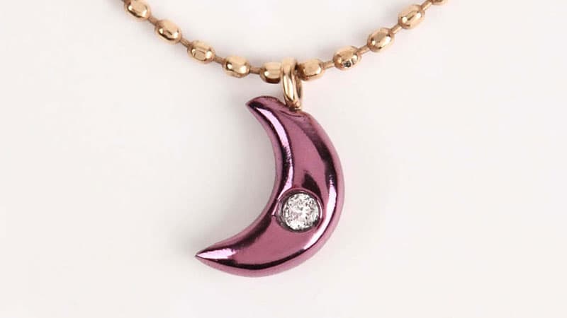 18 karat gold crescent pendant with a striking purple hue